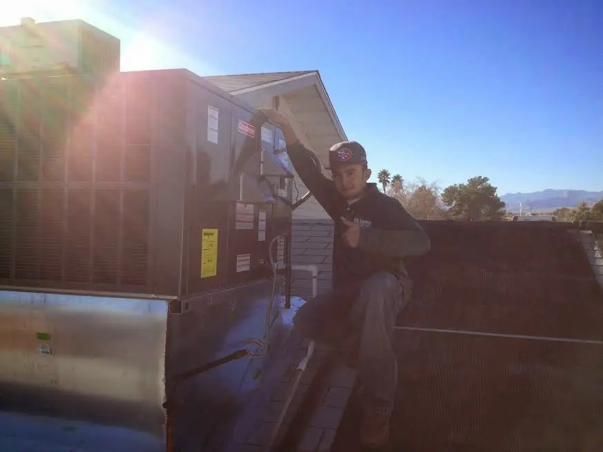 HVAC technician performing AC Tune-Up on a rooftop unit in East Hills